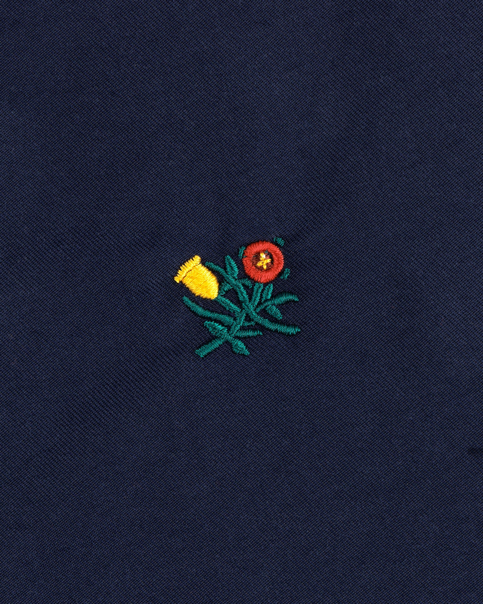Embroidered yellow and red flowers with green stems adorn the Crest Casual Jacket's dark blue fabric.