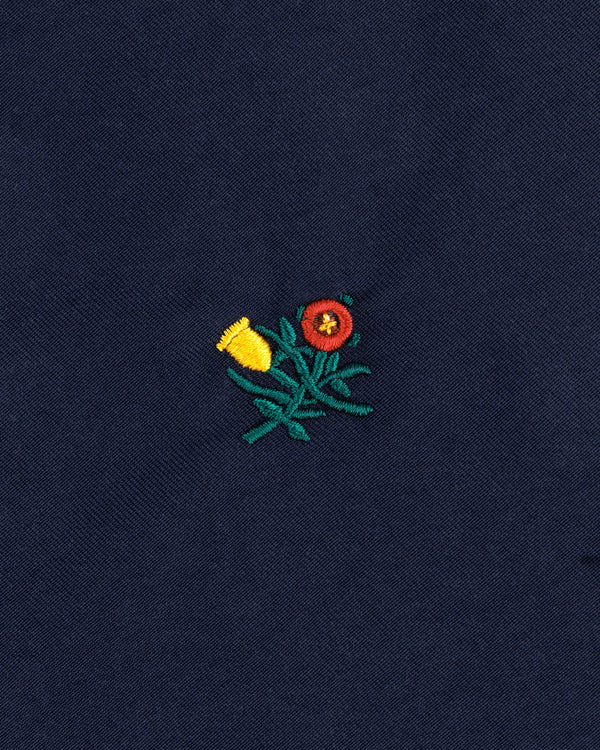 Embroidered yellow and red flowers with green stems adorn the Crest Casual Jacket's dark blue fabric.