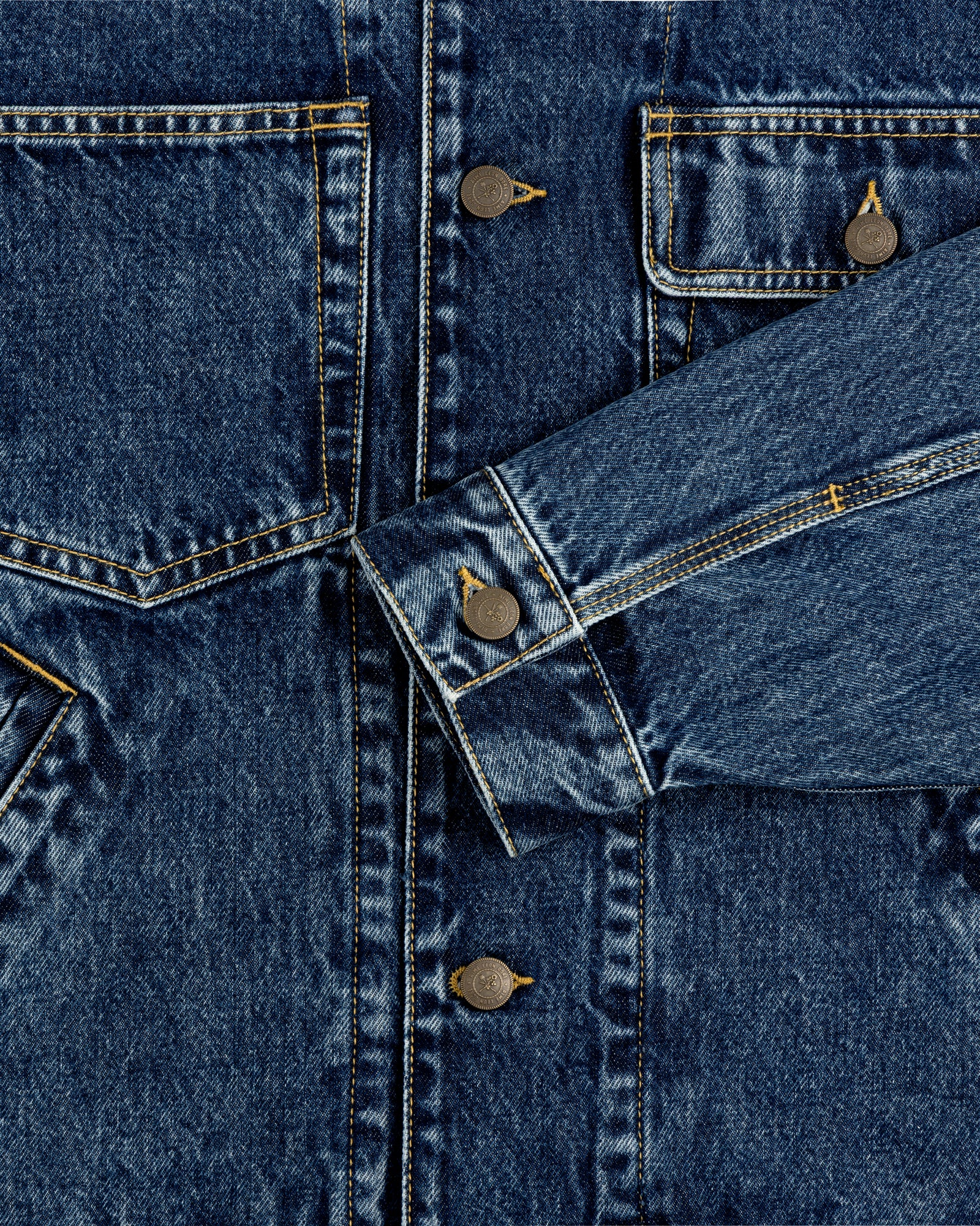 Close-up of Denim Trucker Jacket with front pockets, visible buttons, and detailed stitching.
