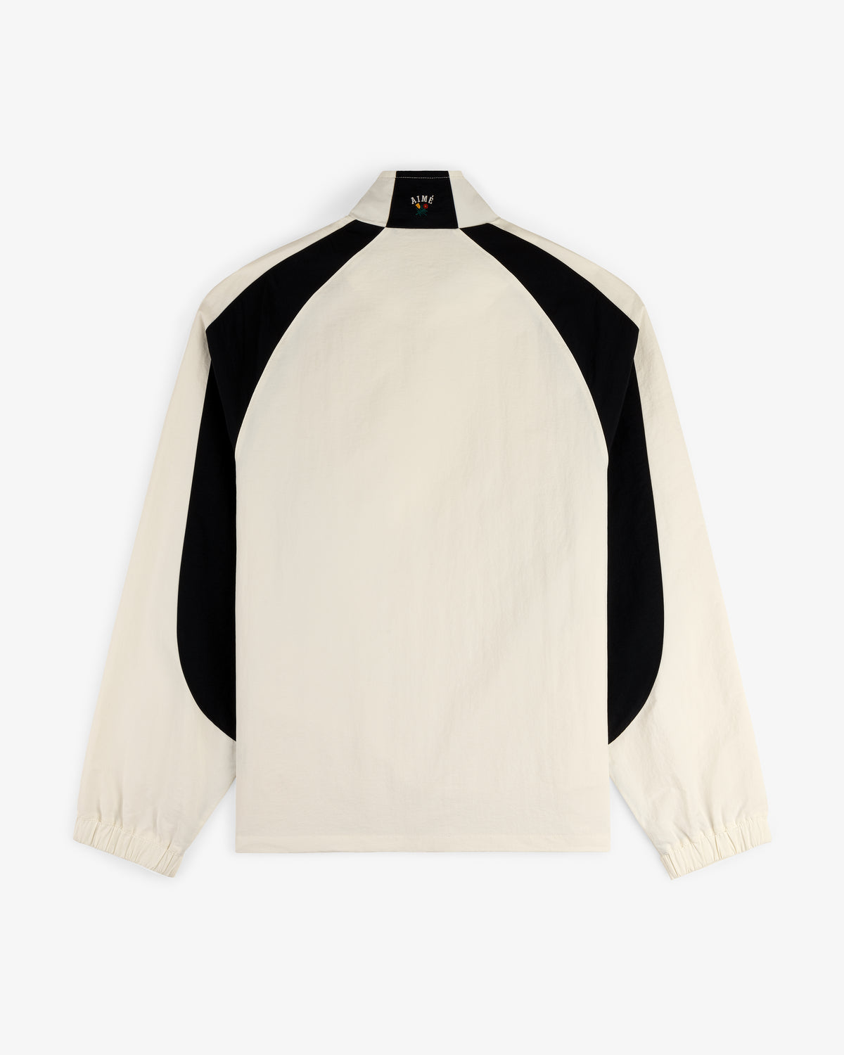 Crest Nylon Half-Zip Pullover in beige with black curved back panels and elastic cuffs, shown on white background.