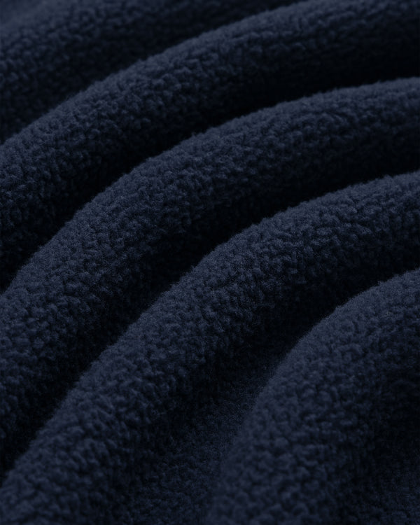 Close-up of Crest Quarter-Zip Fleece Pullover in dark blue, showing soft, wavy textured ridges on the fabric.