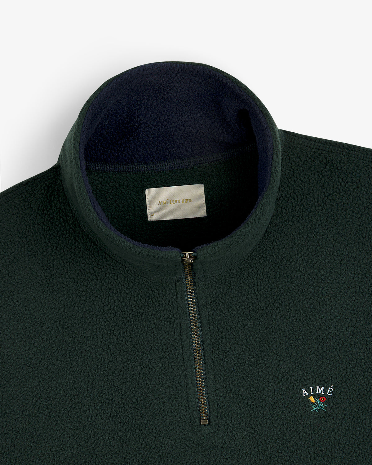 Dark green Crest Quarter-Zip Fleece Pullover with AIMÉ and a small flower embroidered on the chest.