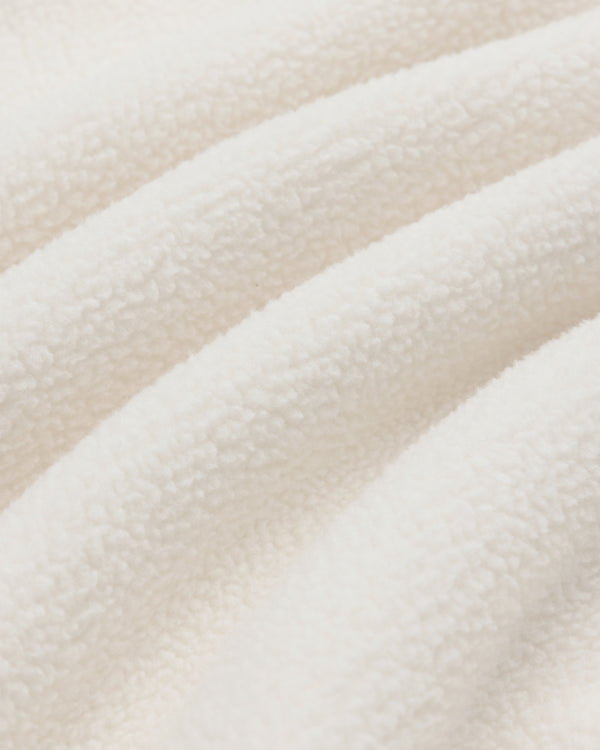 Close-up of Crest Quarter-Zip Fleece Pullover's soft, white fleece with a textured surface and gentle folds.