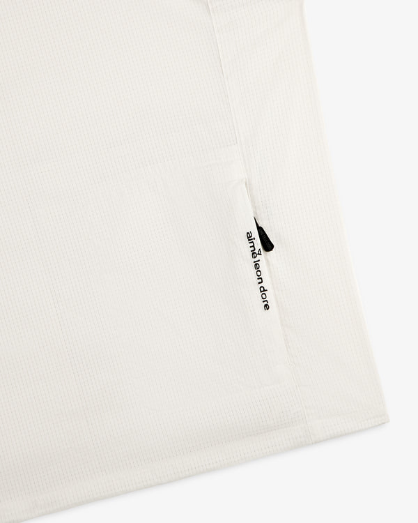 White textured ALD Golf Lightweight Tips Windbreaker with a small vertical zipper pocket and aimé leon dore text.