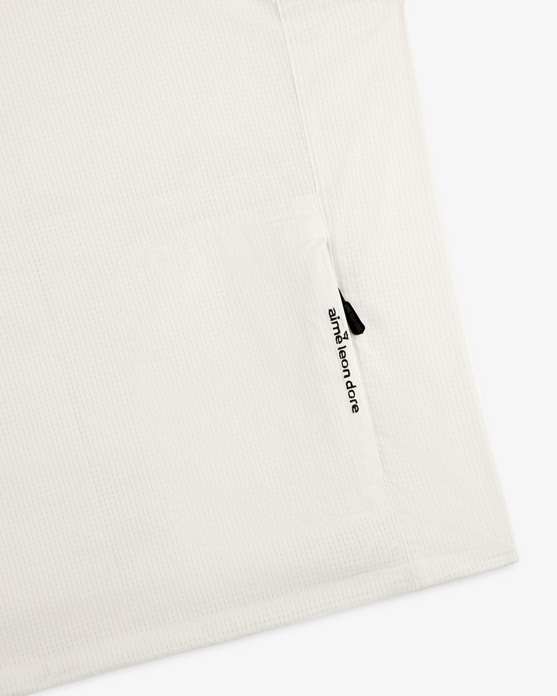 White textured ALD Golf Lightweight Tips Windbreaker with a small vertical zipper pocket and aimé leon dore text.