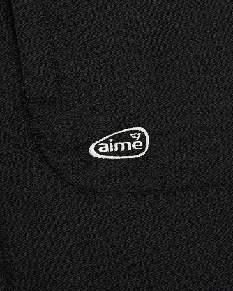 Black textured fabric ALD Golf Lightweight Tips Windbreaker with small white aime logo embroidered on pocket.