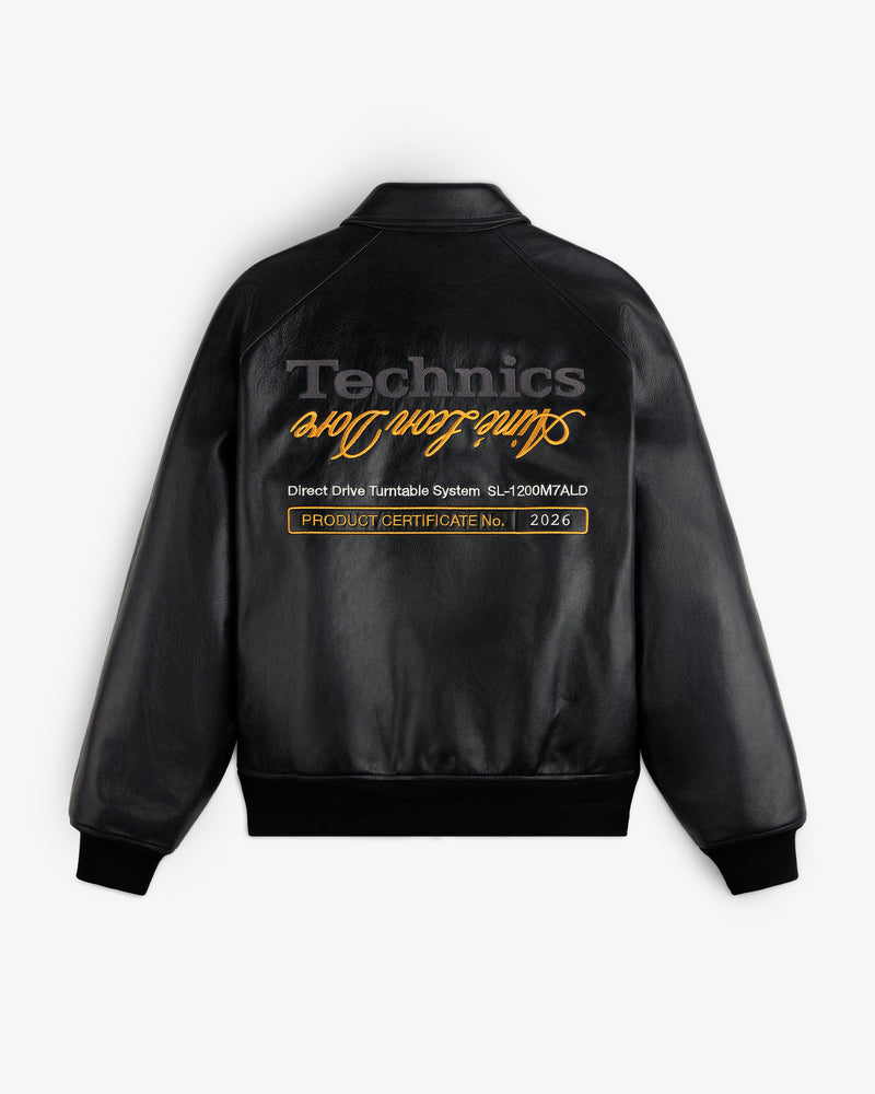 ALD / Technics Varsity Leather Jacket: black leather, gold cursive text on back, with product certificate label.