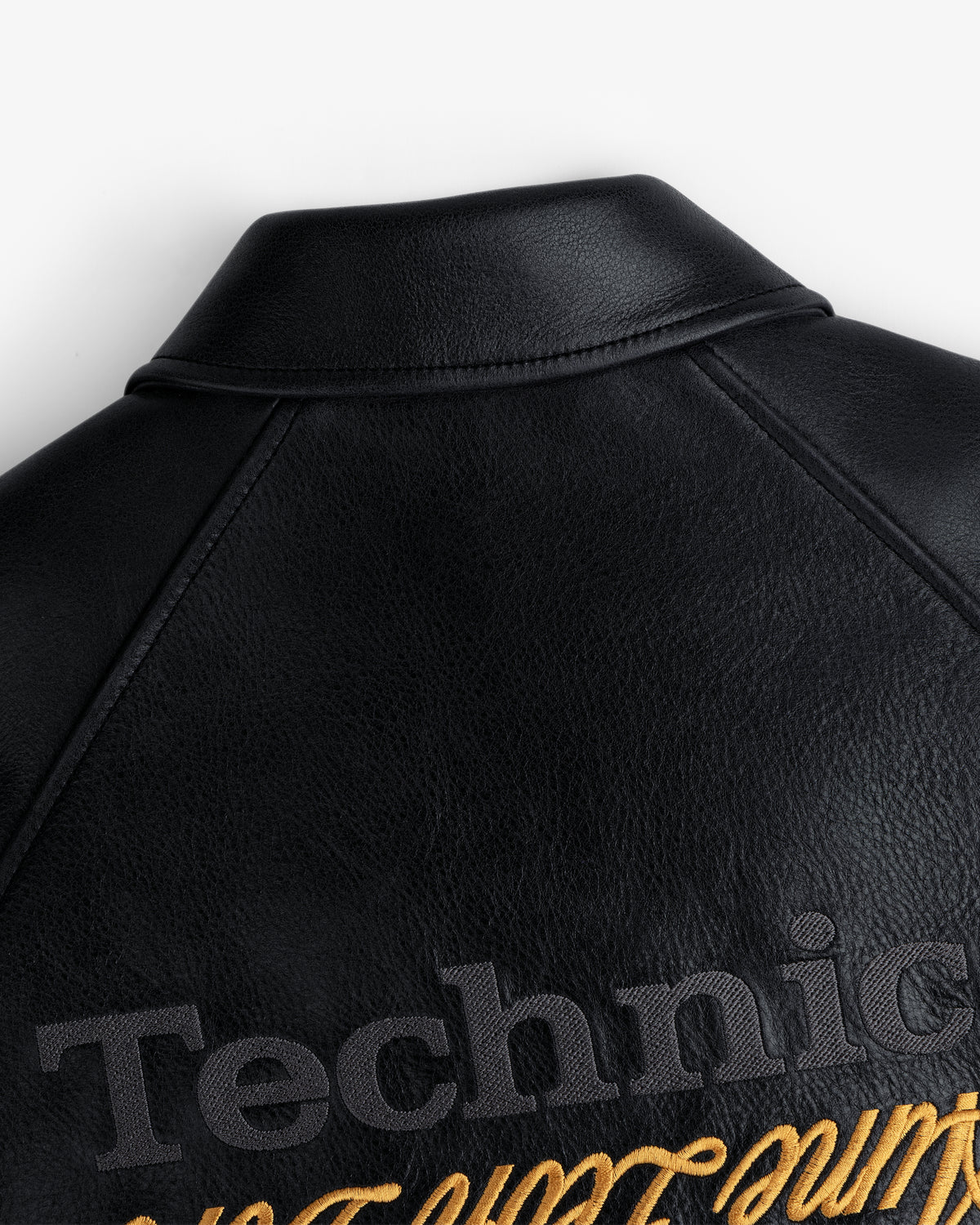 ALD / Technics Varsity Leather Jacket with embossed Technic text and gold script embroidery below the collar.
