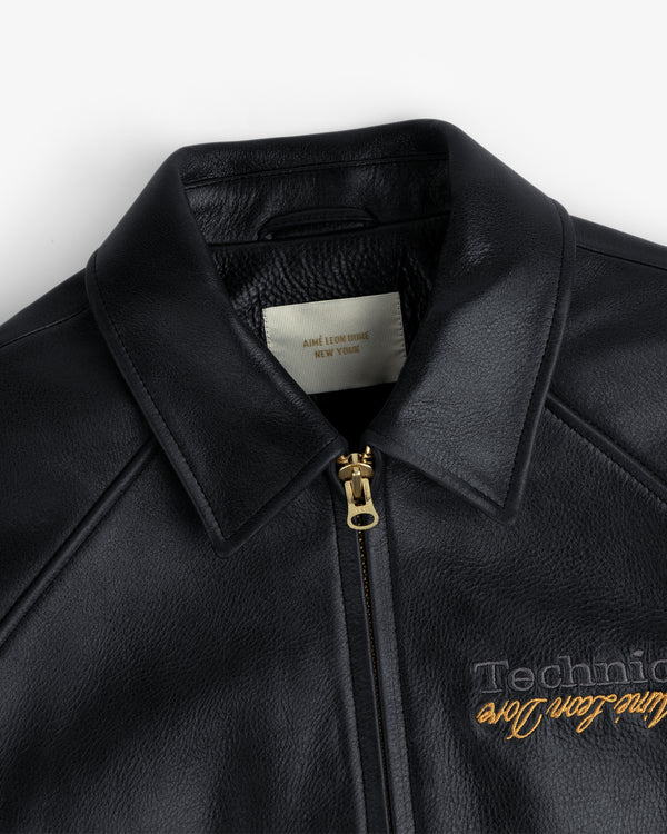 Close-up of the ALD / Technics Varsity Leather Jacket in black leather with gold zipper, showing collar and label.