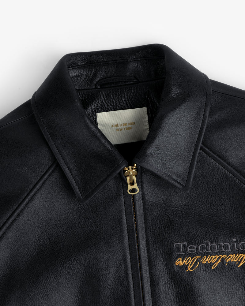 Close-up of the ALD / Technics Varsity Leather Jacket in black leather with gold zipper, showing collar and label.