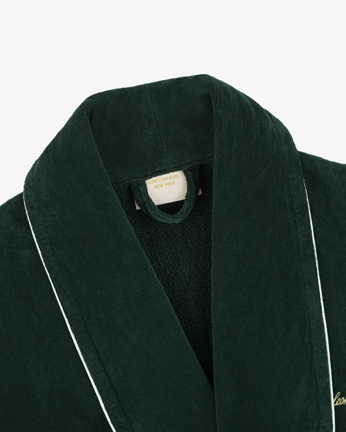 Close-up of a dark green corduroy Mulberry Robe with white piping and a label reading ASCOT LODGE ROBE, NEW YORK.
