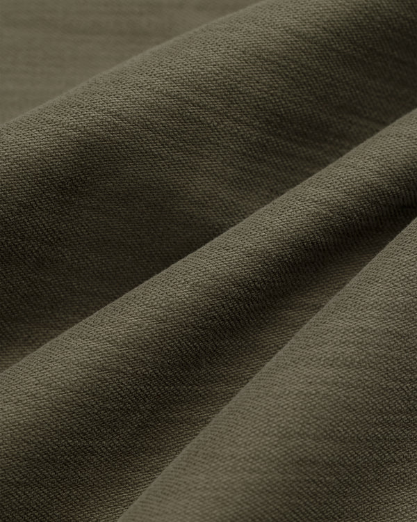 Close-up of Double Pleated Pant in olive green, showing the weave pattern and soft folds with gentle shadows.