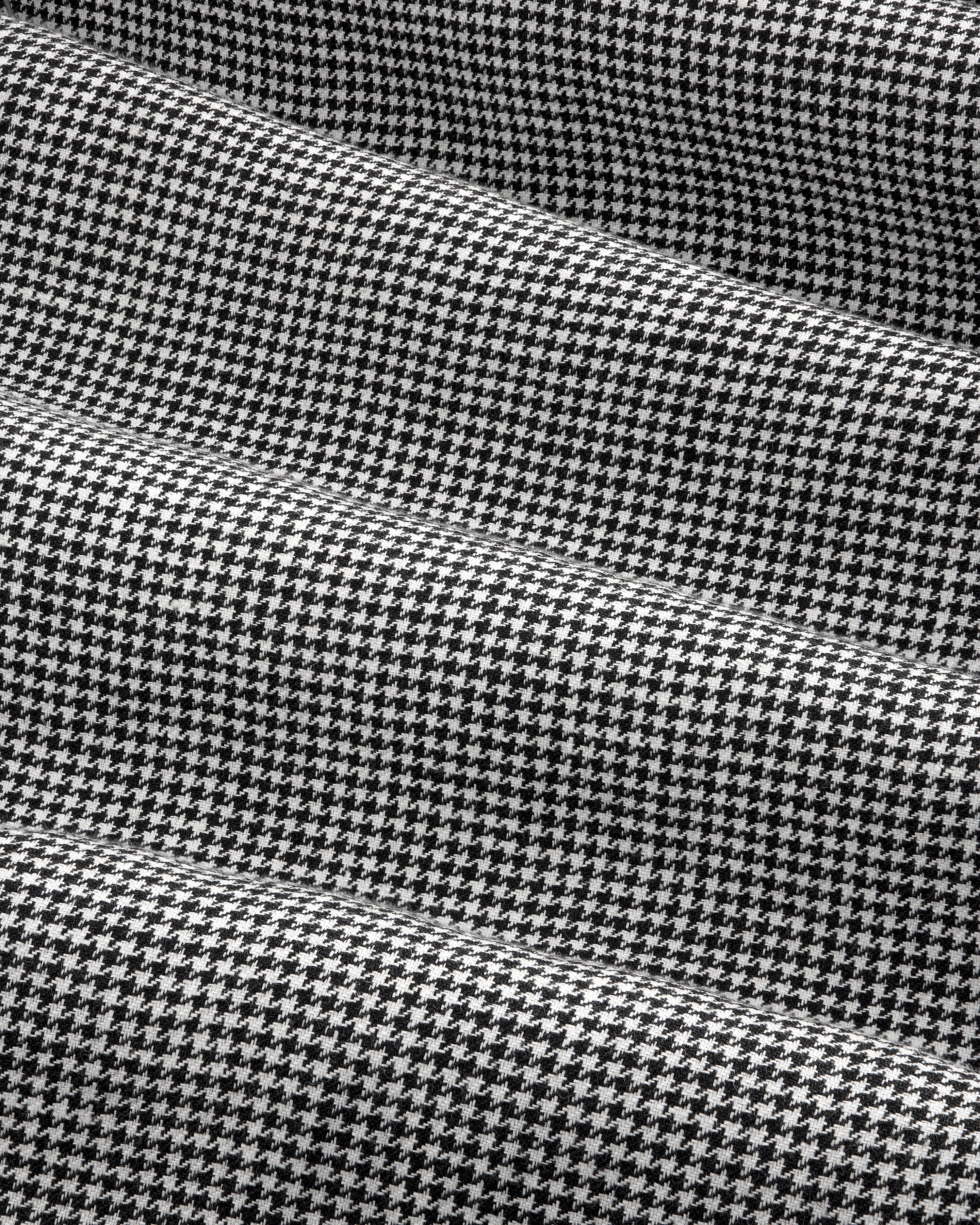 Black and white houndstooth Pleated Trouser with gentle folds and a soft, textured appearance.