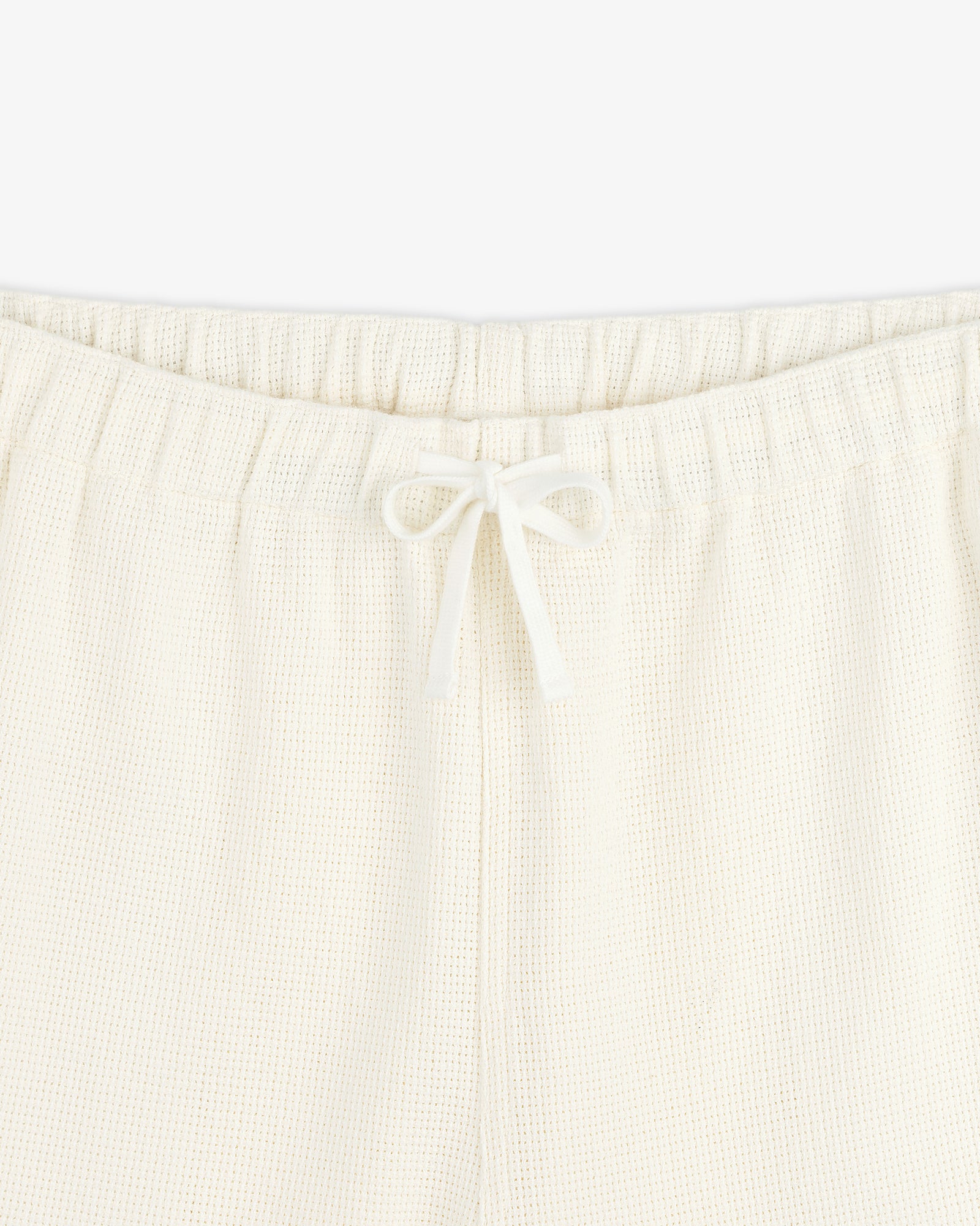 Close-up of Wide Leg Shore Pant in cream with elastic waistband and center-tied drawstring.