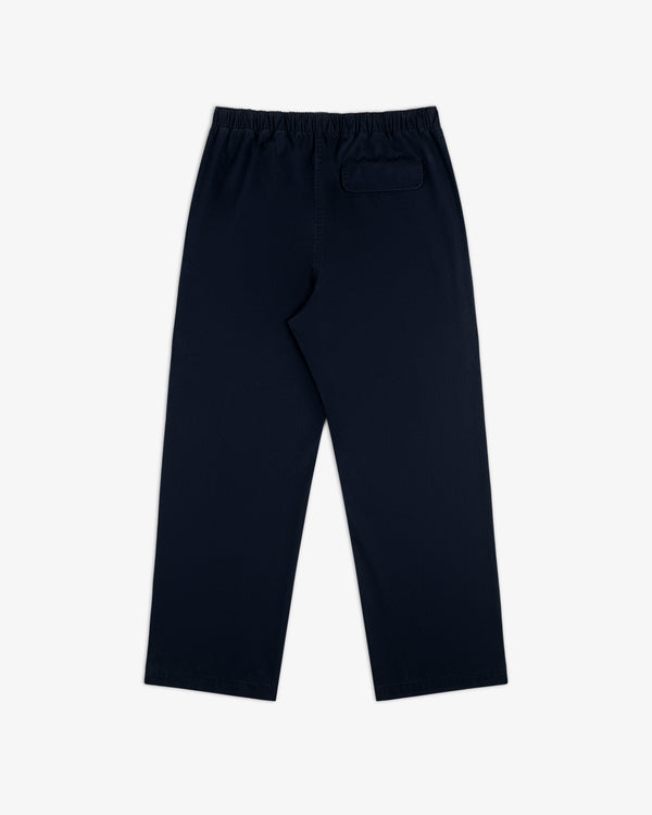 Washed Cotton Windbreaker Pant in navy blue with elastic waistband and single back pocket, shown on white background.