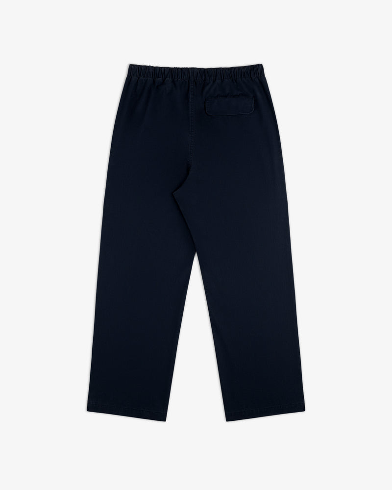 Washed Cotton Windbreaker Pant in navy blue with elastic waistband and single back pocket, shown on white background.