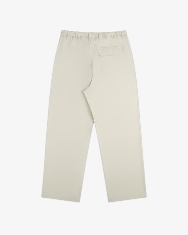 Washed Cotton Windbreaker Pant in beige, straight-leg with elastic waistband and single back pocket, shown flat.