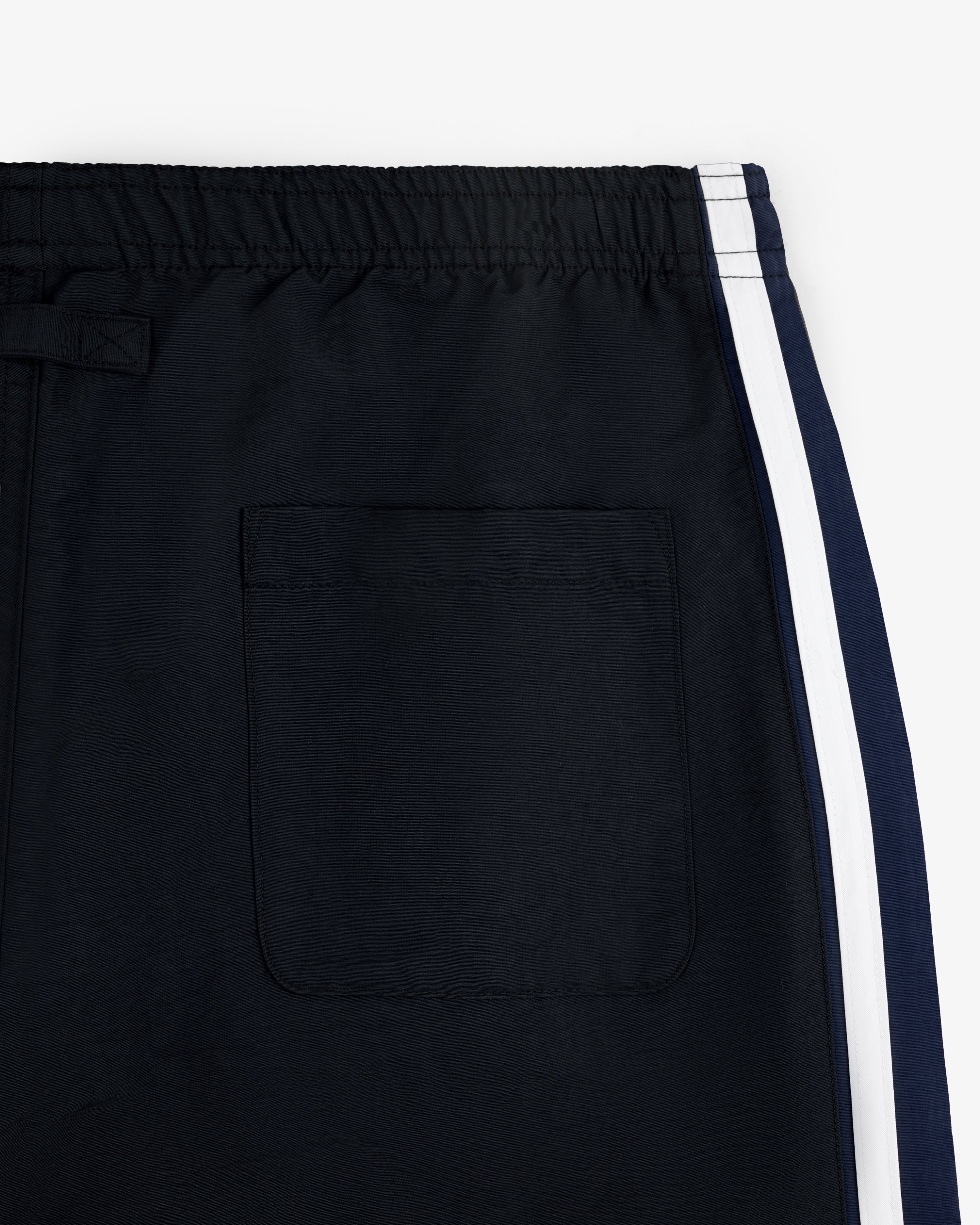 Close-up of Colorblock Track Pant with elastic waistband, white side stripe, and back pocket.