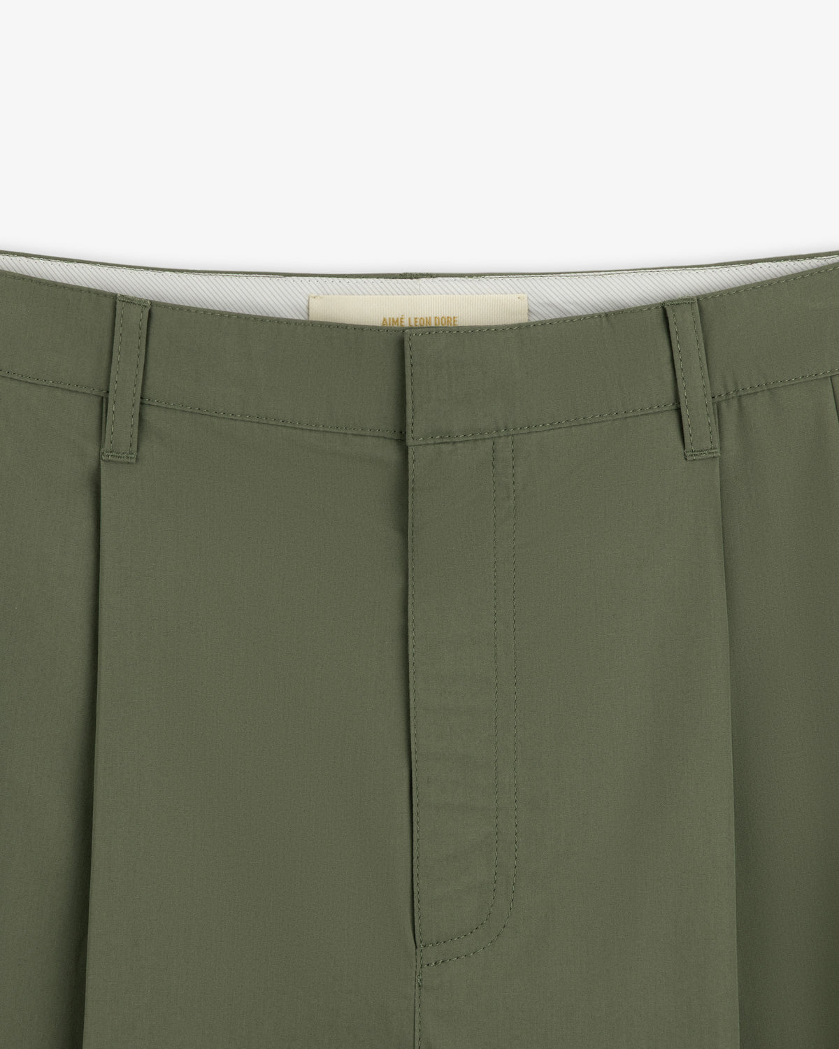 Close-up of the waistband and front of Lightweighted Pleated Cotton Trousers in olive with hidden hook-and-bar closure.