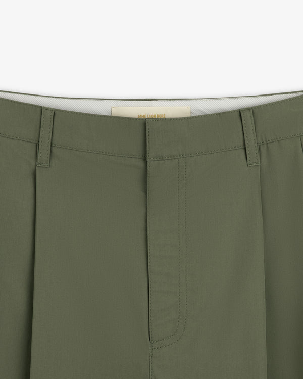 Close-up of the waistband and front of Lightweighted Pleated Cotton Trousers in olive with hidden hook-and-bar closure.