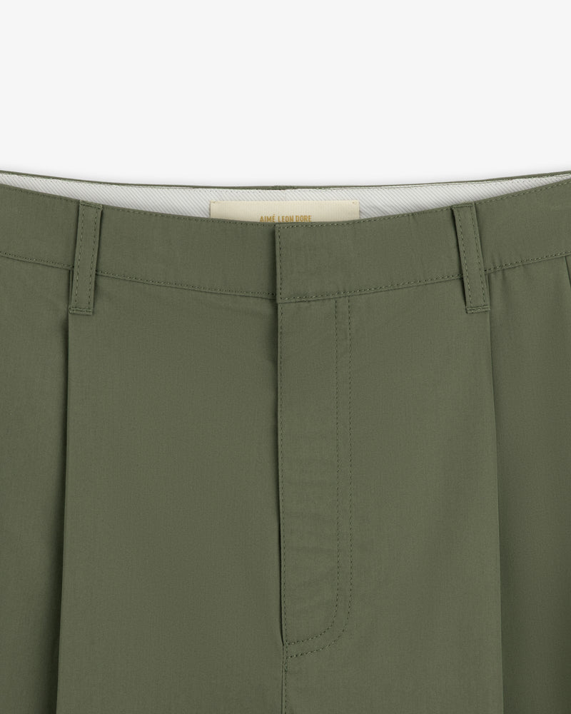 Close-up of the waistband and front of Lightweighted Pleated Cotton Trousers in olive with hidden hook-and-bar closure.
