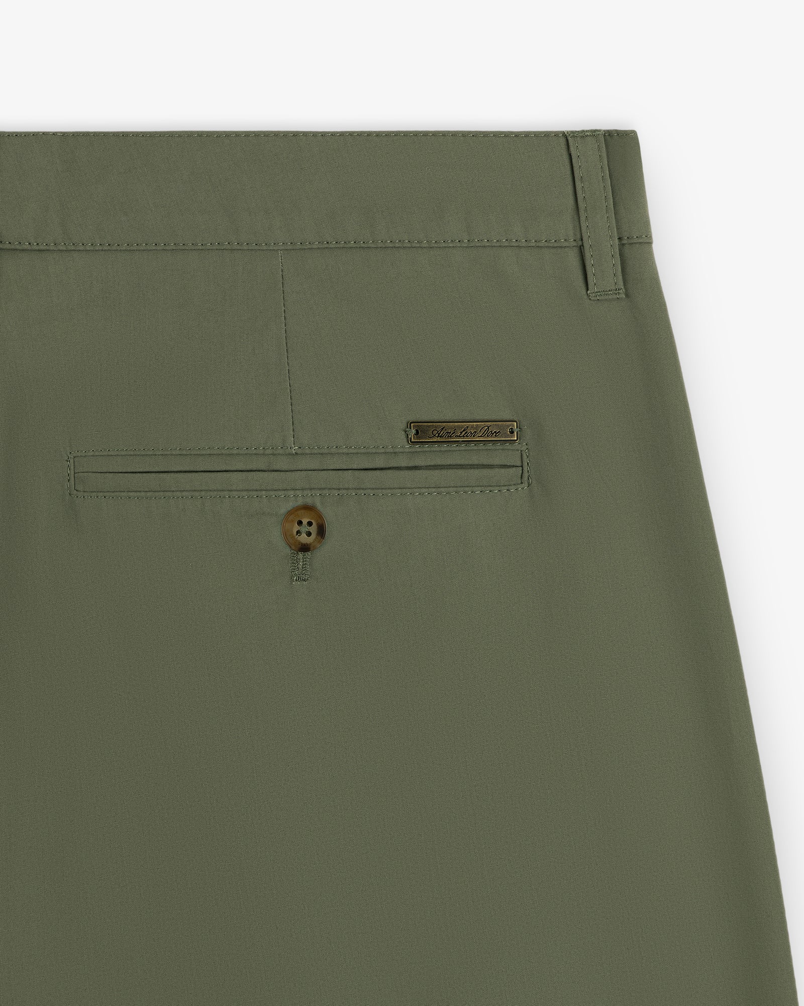 Close-up of Lightweighted Pleated Cotton Trouser in olive green with back pocket, button, and metal brand tag.