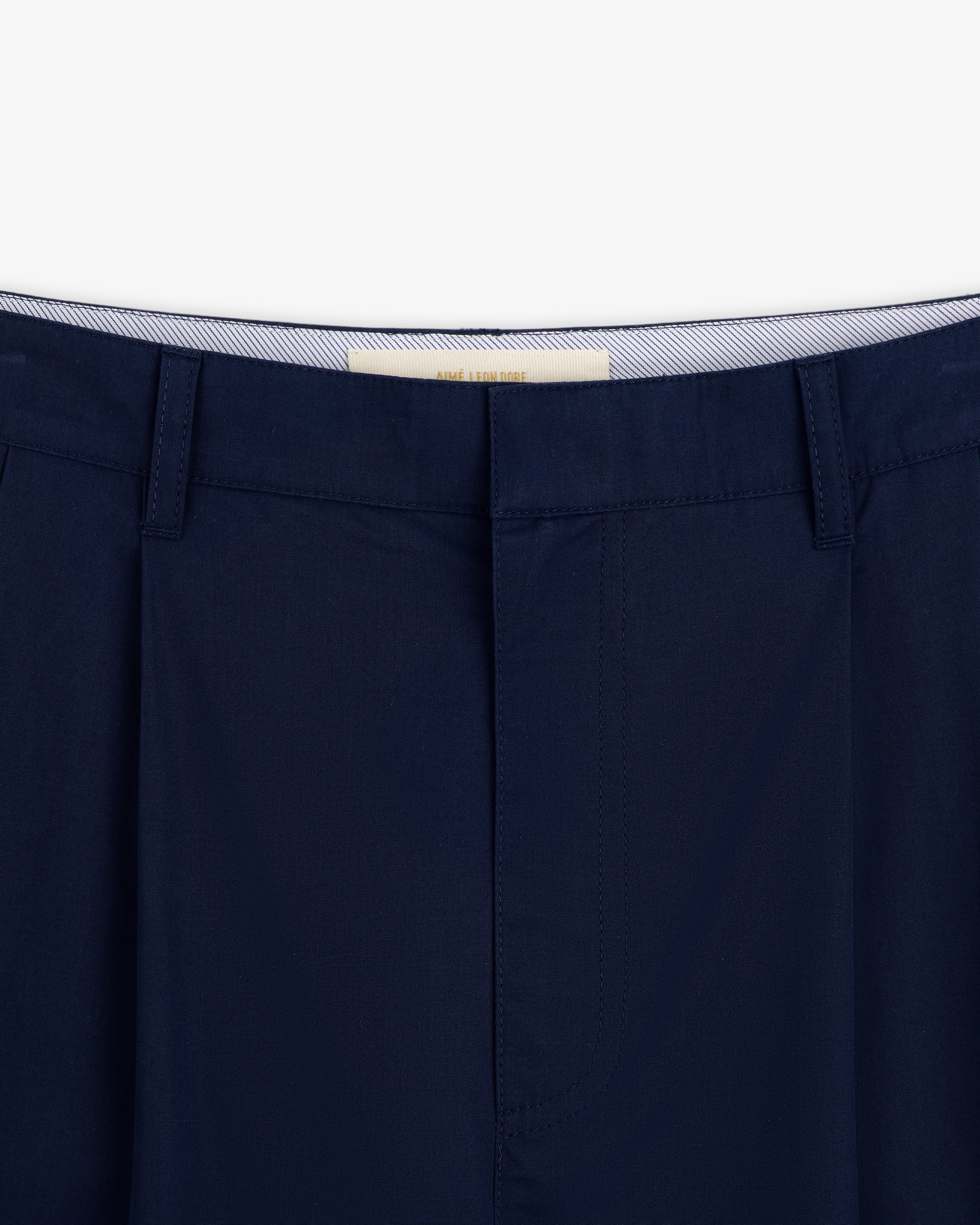 Close-up of the waistband and top of Lightweighted Pleated Cotton Trouser in dark blue with belt loops and concealed closure.