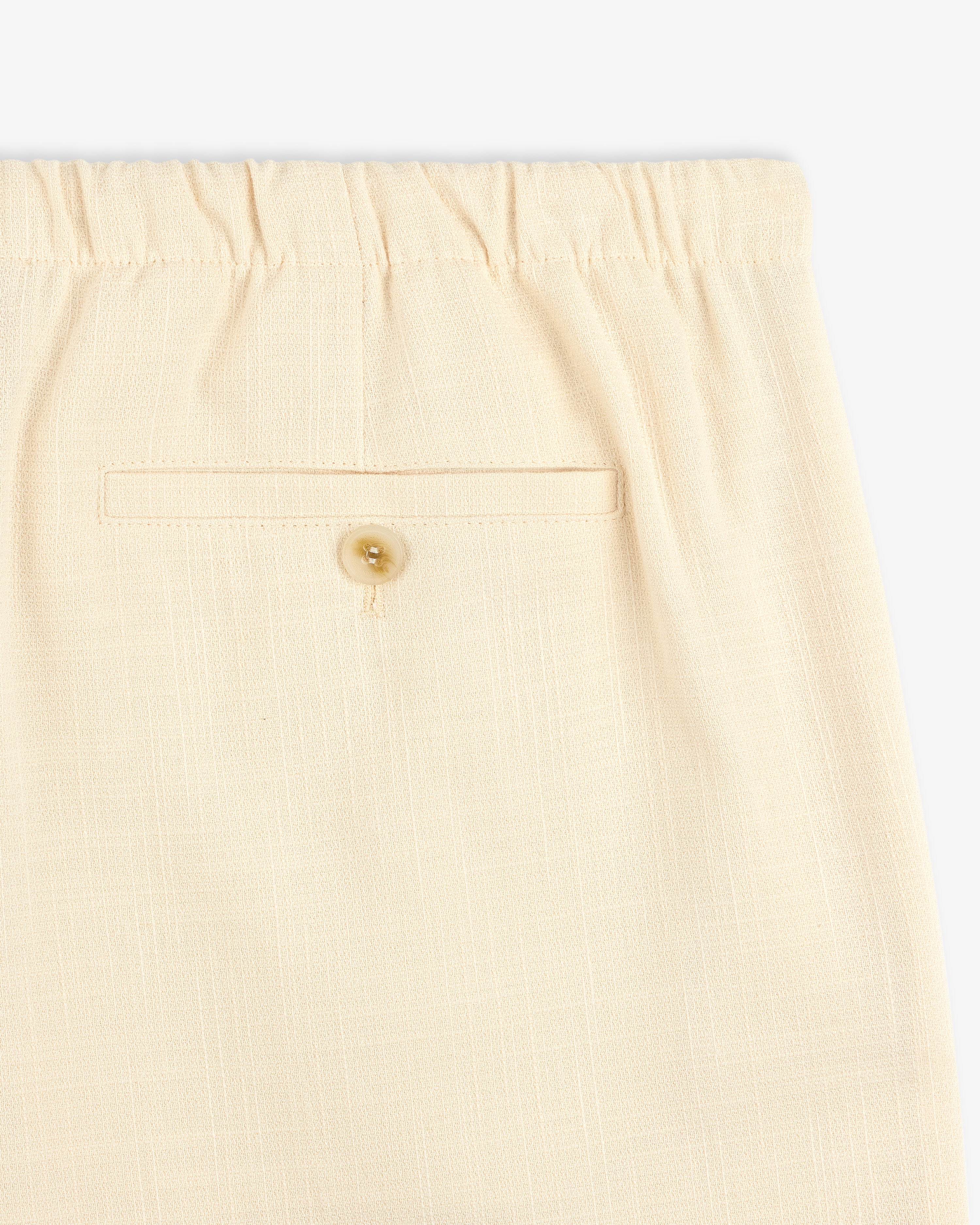 Close-up of Drawstring Cotton Blend Suit Trouser in beige, featuring an elastic waistband and a buttoned back pocket.