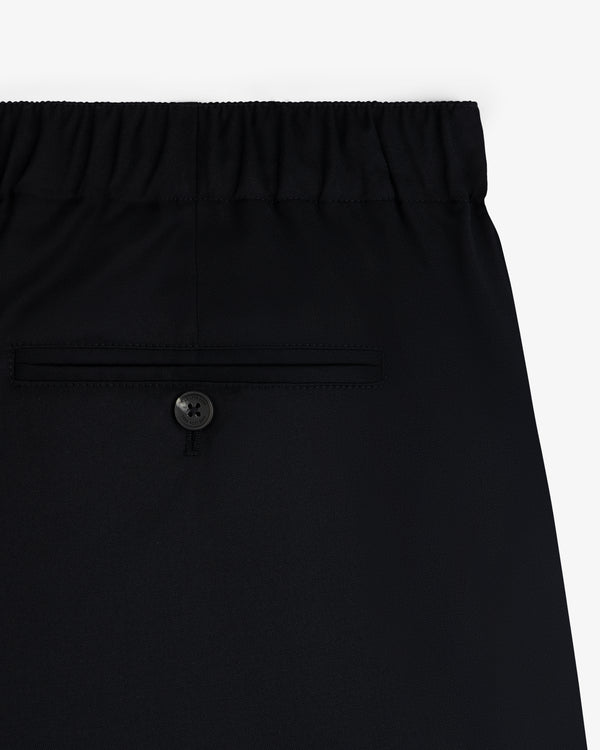 Close-up of Elasticated Waist Gabardine Trouser in black with an elastic waistband and a buttoned back pocket.