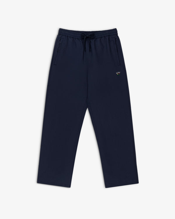 Crest Nylon Track Pant in navy blue with side pockets and a small logo on the left thigh, laid flat on white background.