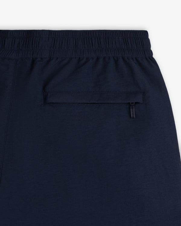 Close-up of Crest Nylon Track Pant in navy blue with elastic waistband and zippered back pocket.