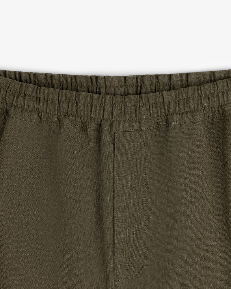 Close-up of Linen Leisure Pant in olive green with elastic waistband and center seam on white background.