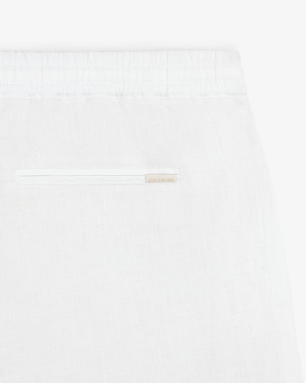 Close-up of Linen Leisure Pant in white, featuring an elastic waistband and a single back slit pocket.