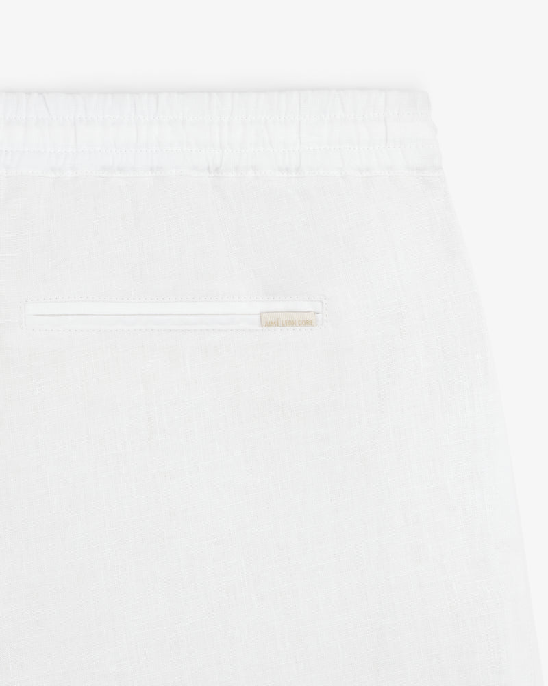 Close-up of Linen Leisure Pant in white, featuring an elastic waistband and a single back slit pocket.