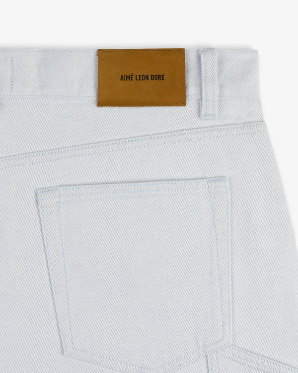 Close-up of Light Wash Denim Short with a brown Aimé Leon Dore leather patch above the back pocket.