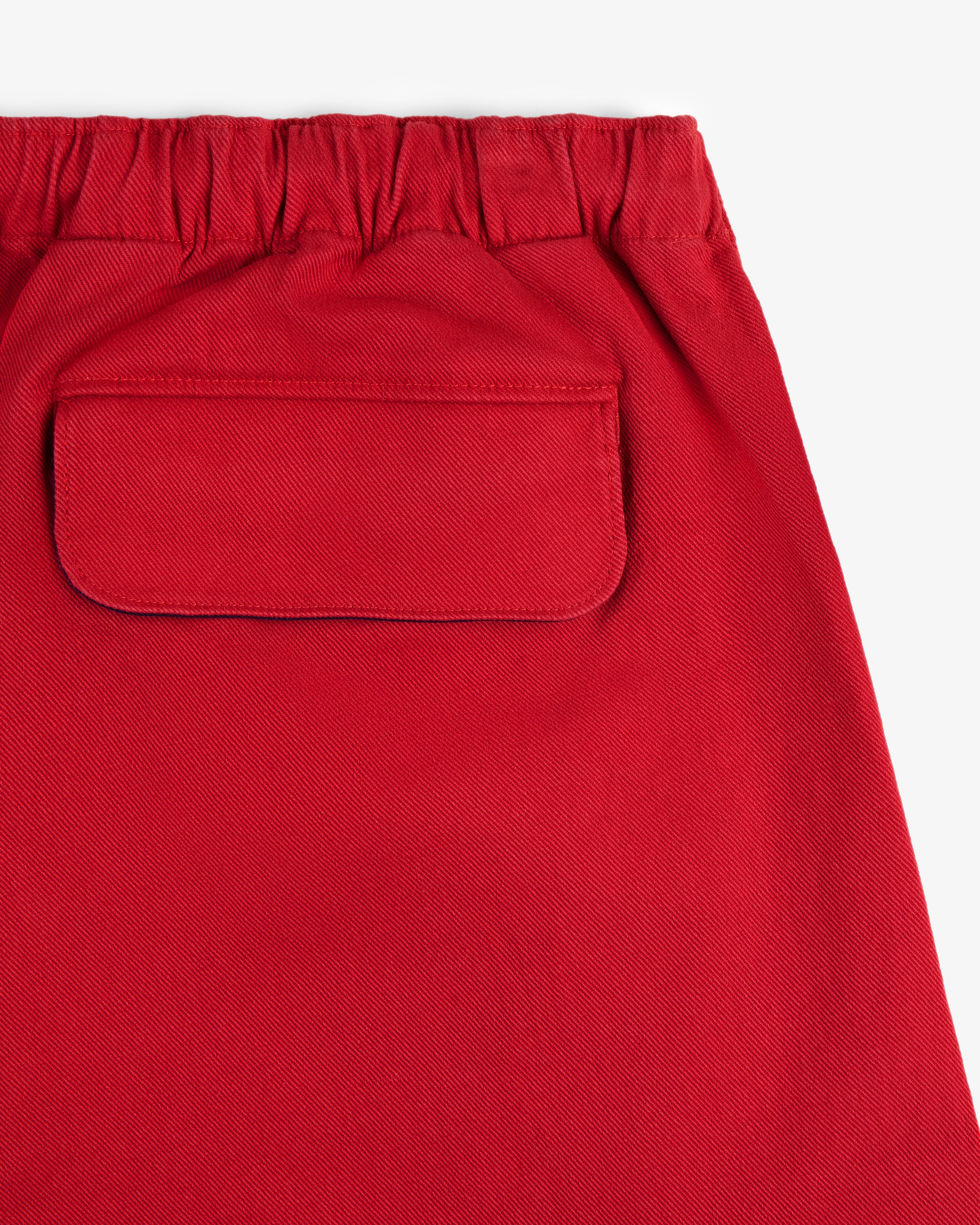 Close-up of Crest Casual Short in red featuring an elastic waistband and a back flap pocket.