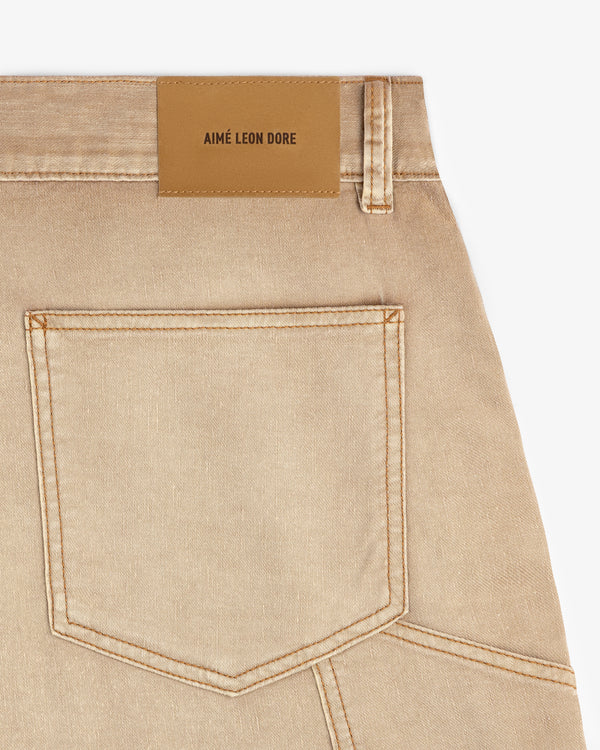 Close-up of beige Garment Dyed Carpenter Short with a back pocket and a tan leather AIMÉ LEON DORE patch.