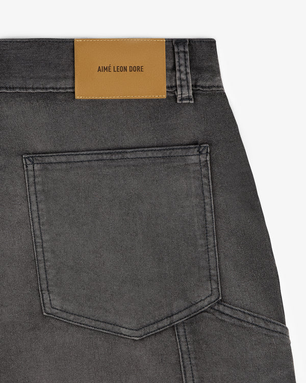 Close-up of Garment Dyed Carpenter Short in black denim with a back pocket and tan AIMÉ LEON DORE leather patch.