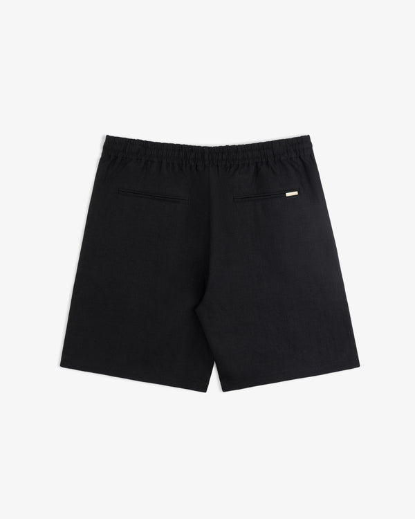 Linen Leisure Short in black with an elastic waistband, two back welt pockets, and a small tag above the right pocket.
