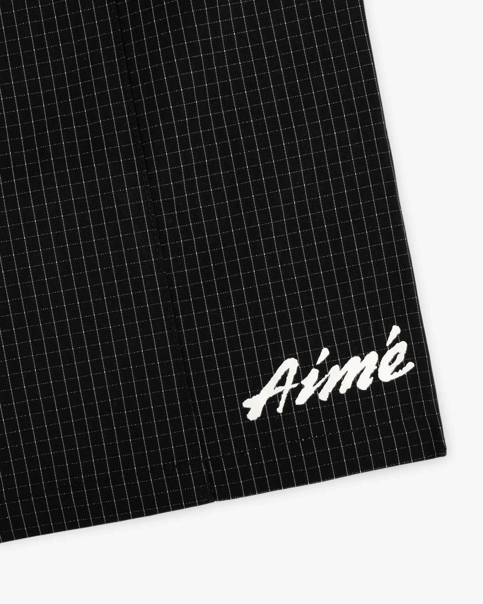 Black Ripstop Nylon Wave Short with a subtle grid and white embroidered Aimé in the bottom right corner.