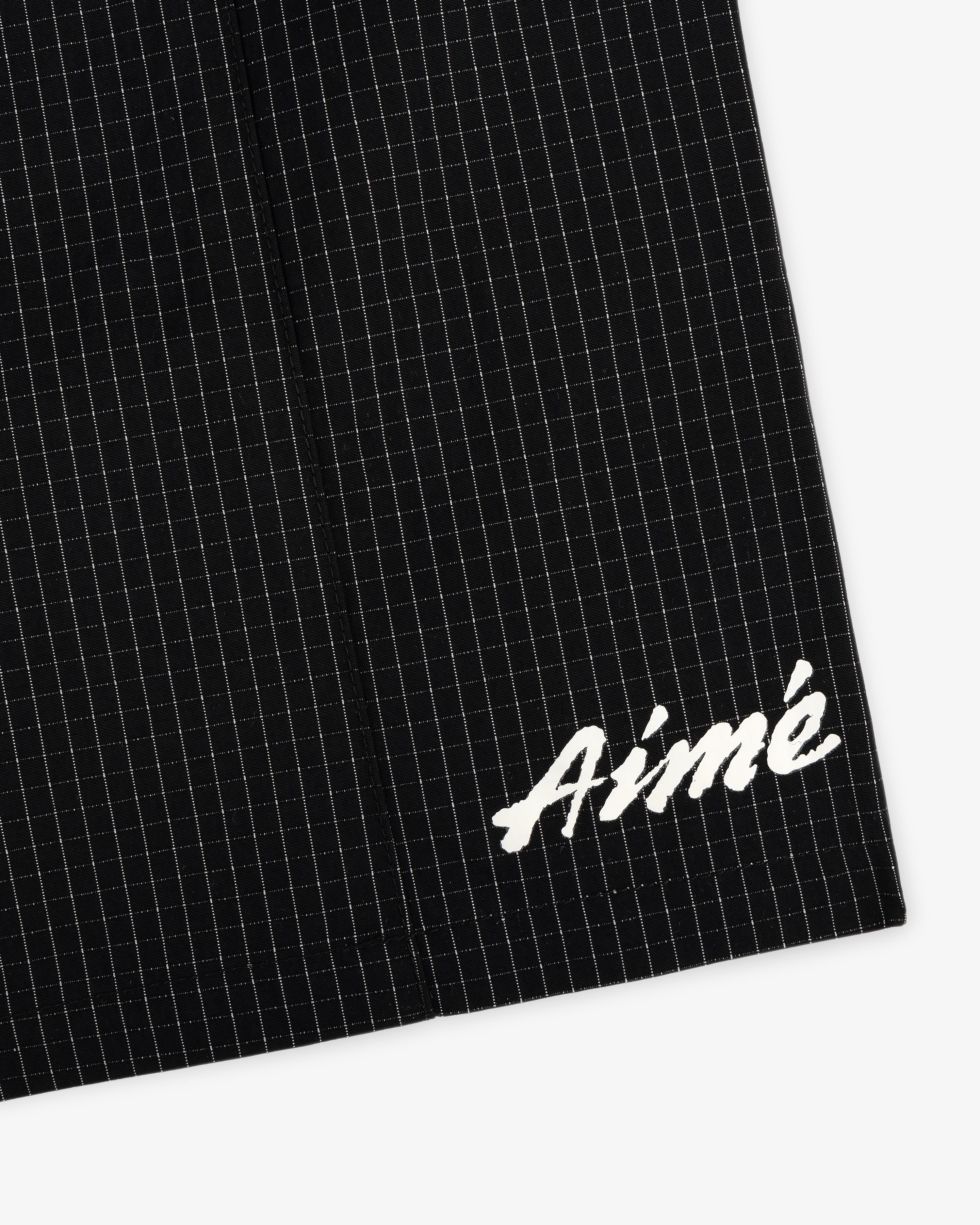 Black Ripstop Nylon Wave Short with a subtle grid and white embroidered Aimé in the bottom right corner.