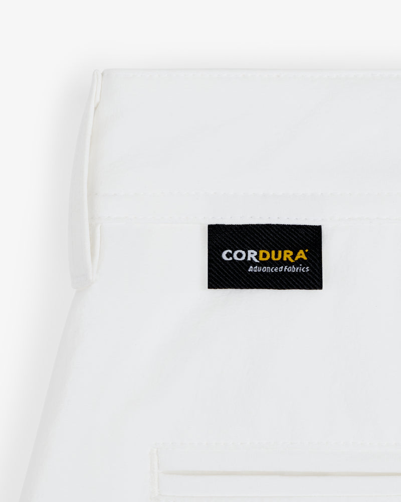 A white ALD Golf Cordura Double Pleated Short with a black CORDURA Advanced Fabrics label sewn near the seam.