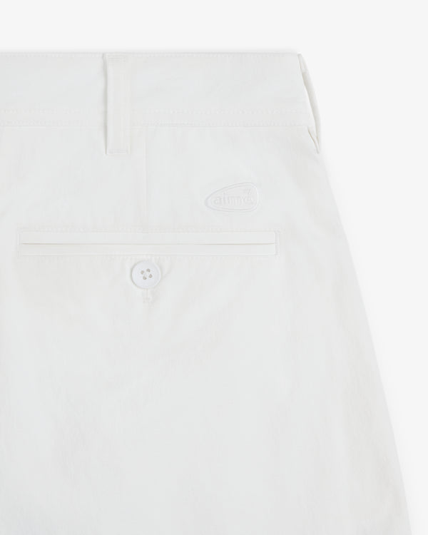Close-up of ALD Golf Cordura Double Pleated Short in white, with a back pocket, button, belt loop, and logo detail.