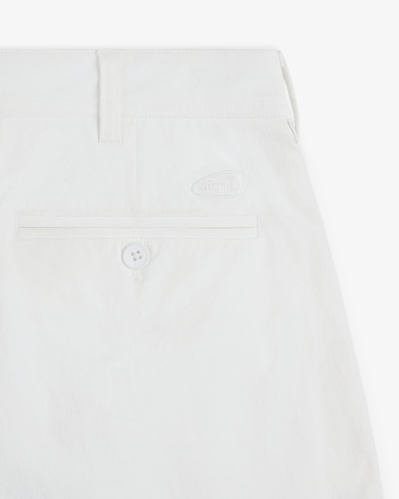 Close-up of ALD Golf Cordura Double Pleated Short in white, with a back pocket, button, belt loop, and logo detail.