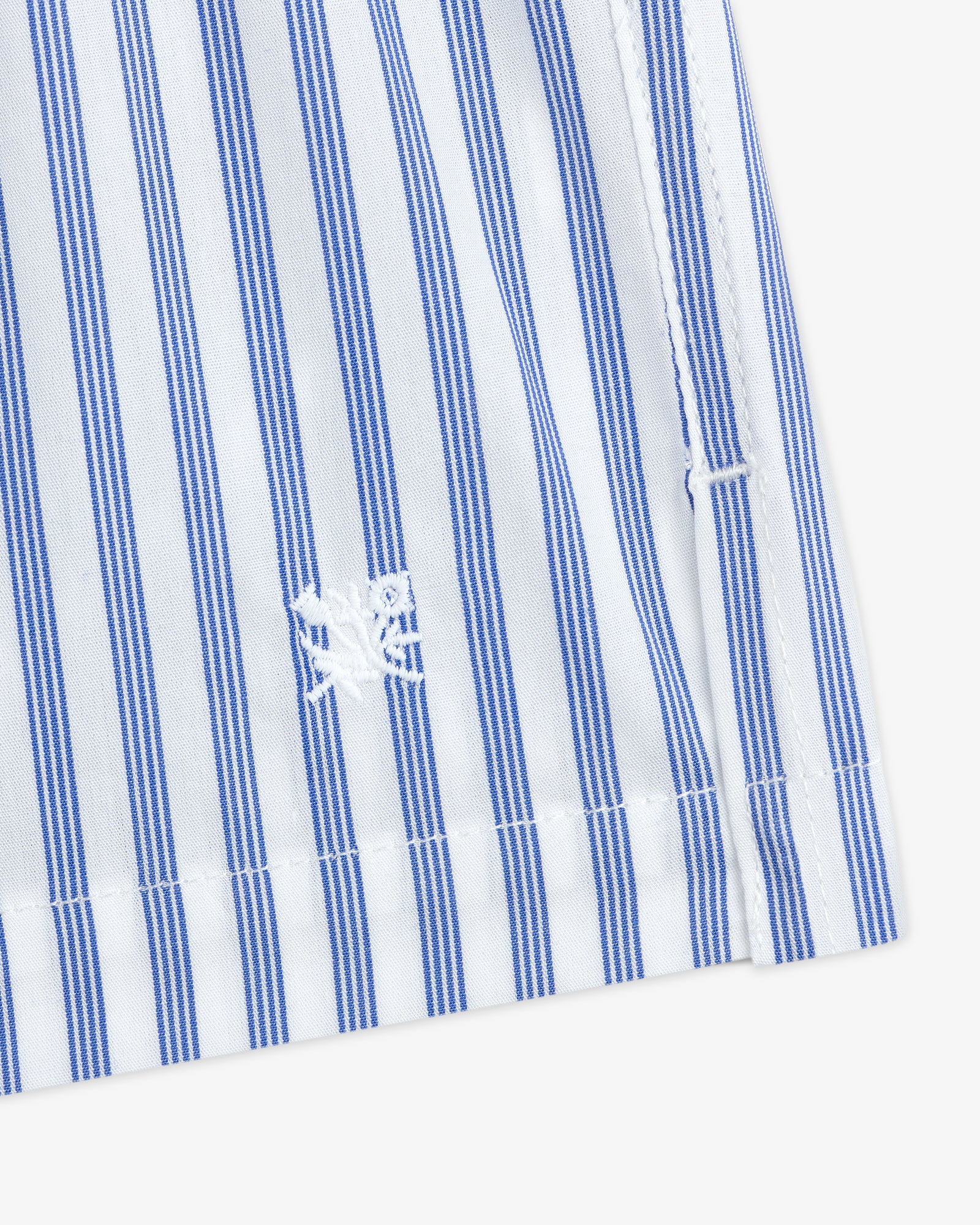 Close-up of Striped Boxer Short in blue and white with a small white embroidered crab near the hem.