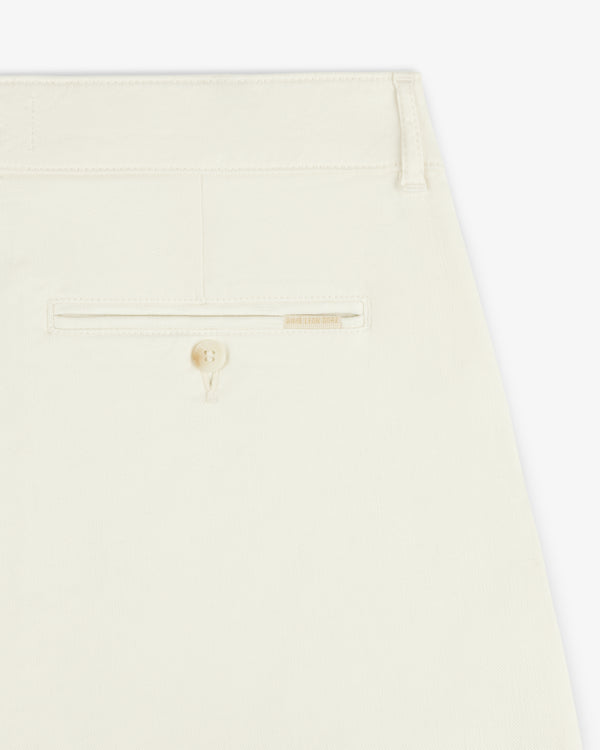 Close-up of the back pocket of Pleated Linen Blend Bermuda Short in cream with a button and beige label above the pocket.