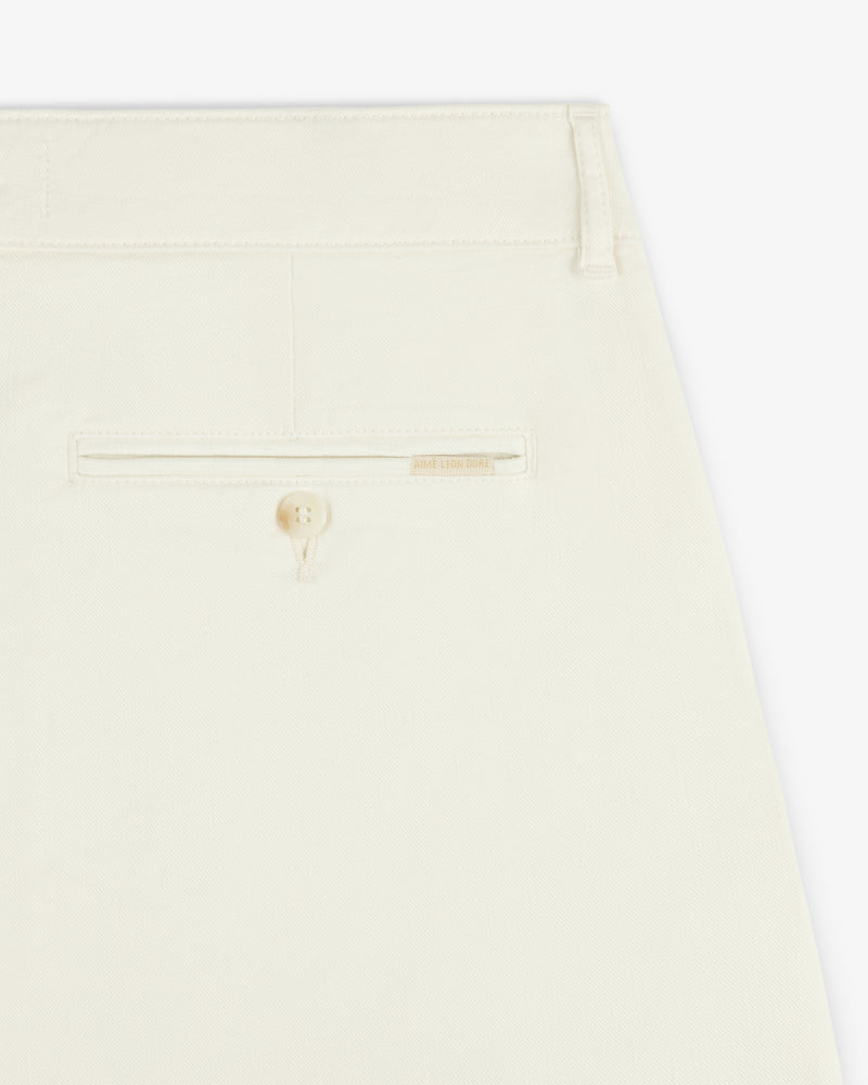 Close-up of the back pocket of Pleated Linen Blend Bermuda Short in cream with a button and beige label above the pocket.