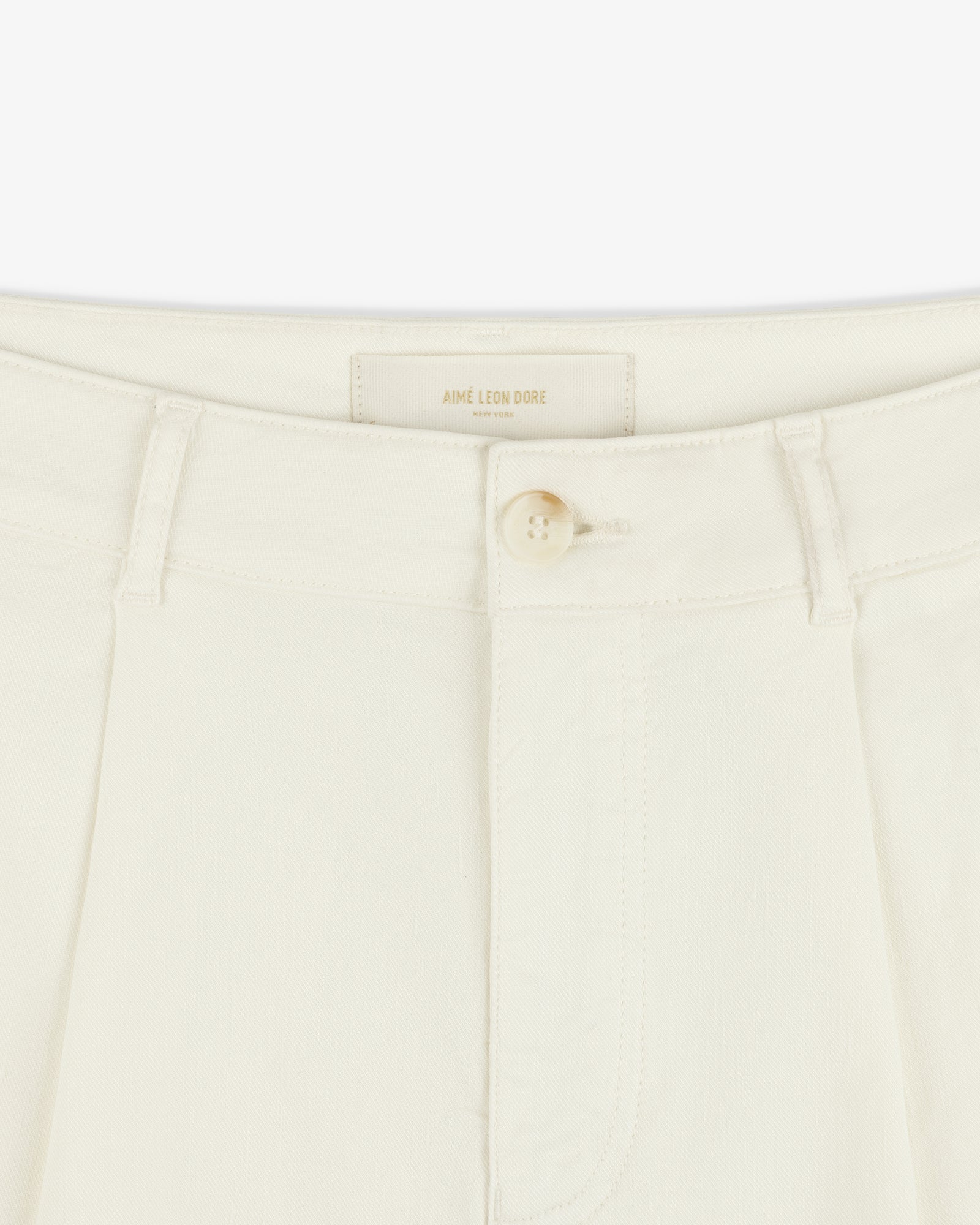 Close-up of Pleated Linen Blend Bermuda Short in cream with a single button and belt loops at the waistband.