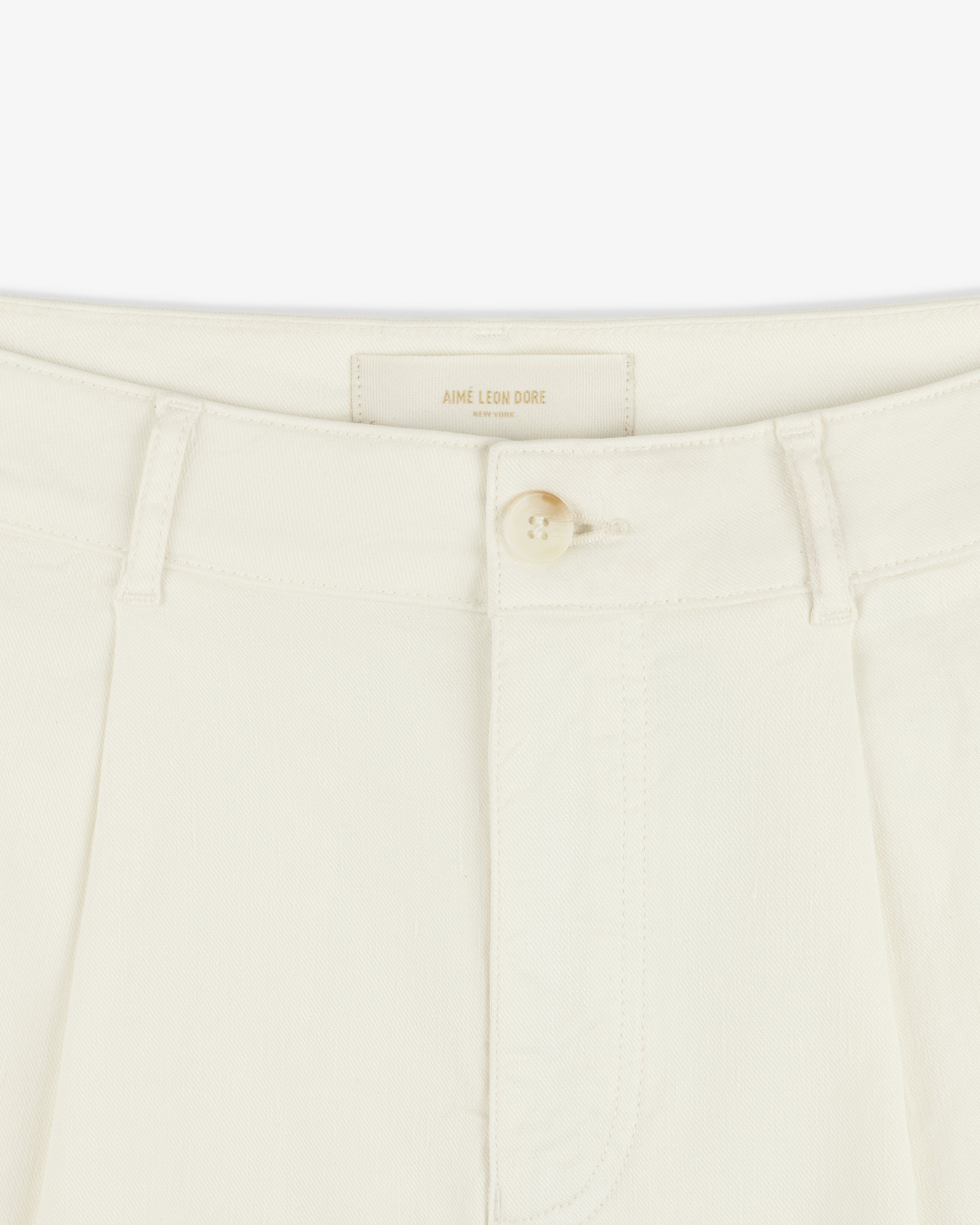 Close-up of Pleated Linen Blend Bermuda Short in cream with a single button and belt loops at the waistband.