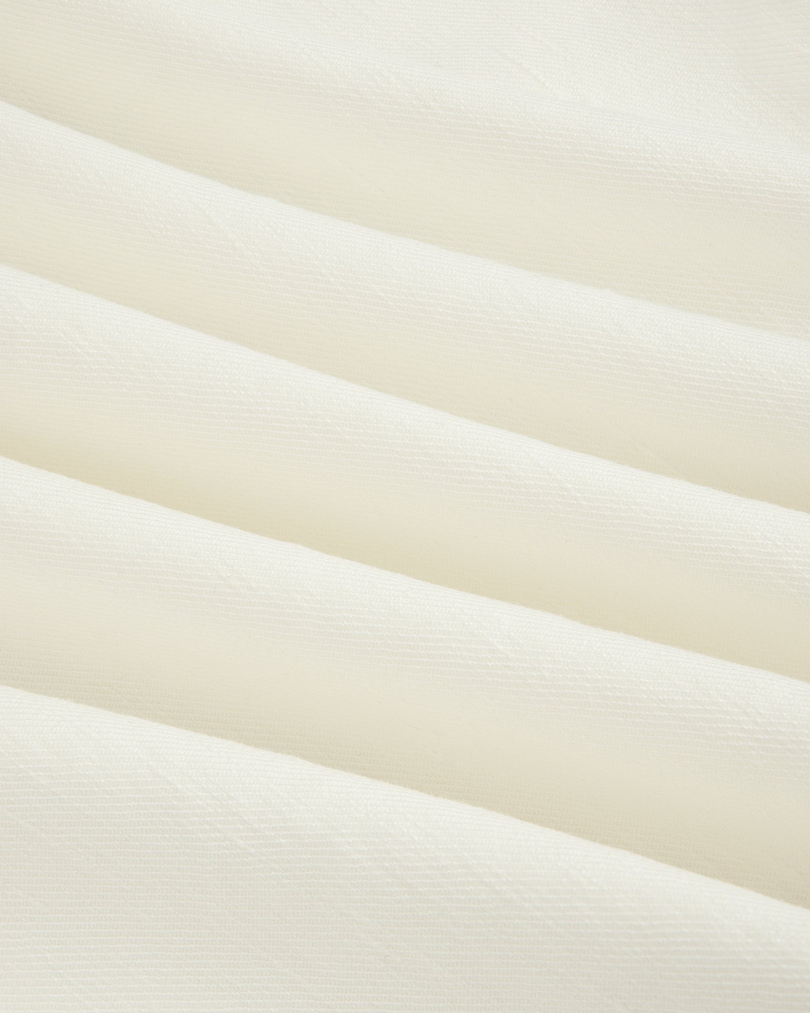 Close-up of Pleated Linen Blend Bermuda Short in white, featuring soft fabric with gentle horizontal folds.